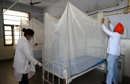 Health worker conducting dengue prevention and mosquito control activities in India.