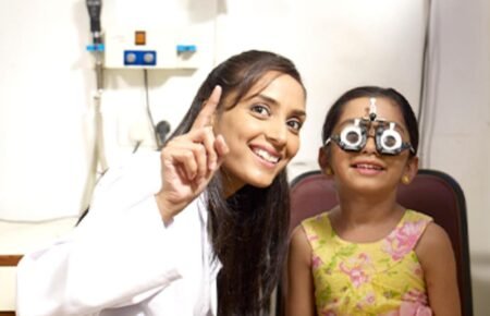 Eye doctor examining a child during a vision check-up in Telangana.