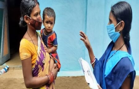 An ASHA worker conducting a home health check-up for a newborn and mother.