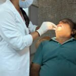 A doctor conducting an oral cancer examination with digital diagnostic support.