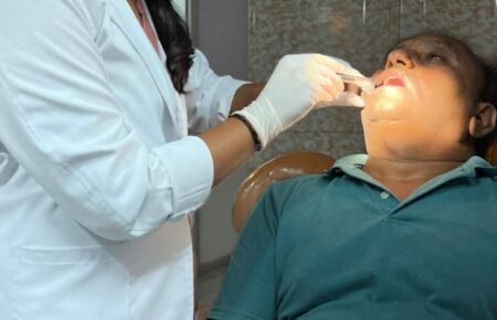 A doctor conducting an oral cancer examination with digital diagnostic support.