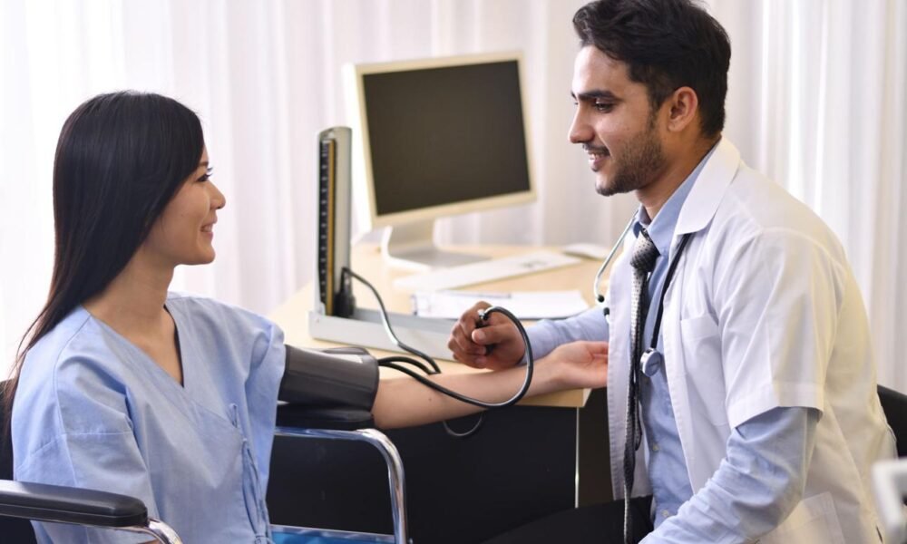 Healthcare workers conducting blood pressure and diabetes screening at a community health camp.
