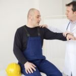 A doctor conducting a health check-up for construction workers at a medical camp.