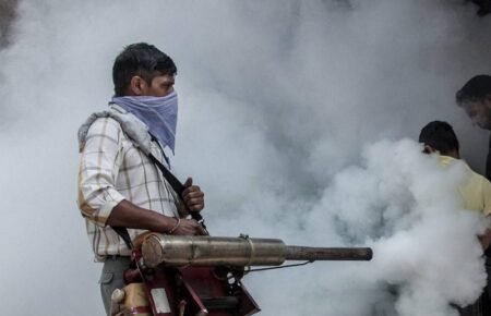 A public health worker carrying out mosquito control measures during a dengue prevention campaign.
