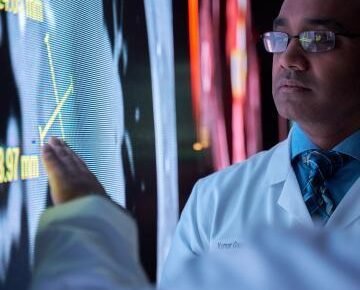 A doctor using AI-assisted software to review cancer screening images.