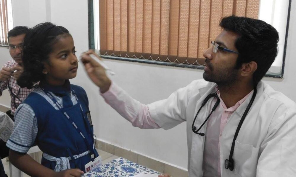 Doctors conducting health check-ups for schoolchildren during a school health screening programme.