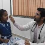Doctors conducting health check-ups for schoolchildren during a school health screening programme.